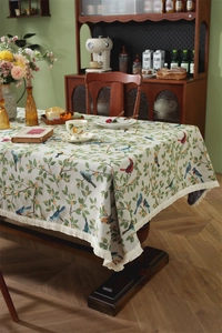 Close-up of retro floral bird jacquard tablecloth with elegant beige fringe tassel edge