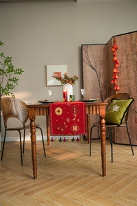 Detail of red festive table runner with golden New Year lanterns and hanging tassels