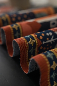 Macro shot of ethnic jacquard table runner with moon patterns and gold thread details