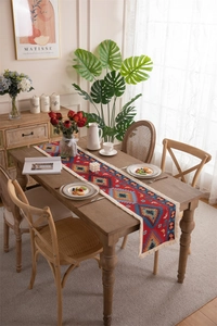 Close-up of red bohemian table runner with geometric jacquard patterns and cotton tassels