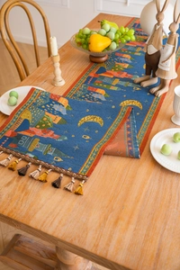 Close-up of jacquard table runner showing vibrant castle patterns and fringed tassels