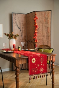 Close-up of red festive table runner with gold Chinese embroidery and colorful tassels