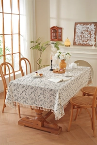 Floral cotton tablecloth with delicate tassels in a warm European rustic dining room