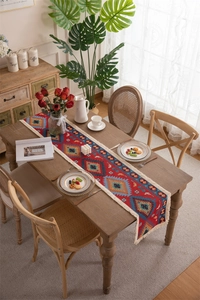 Detailed view of bohemian geometric pattern and cream tassels on a woven table runner