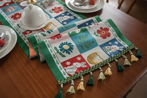 Detail of Easter table runner with bunny patterns and colorful hanging tassels decor