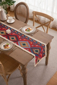 Detail of bohemian jacquard table runner with geometric patterns and beige tassels