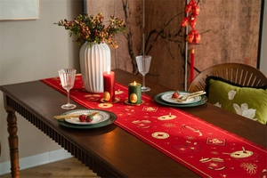 Detail of red Chinese New Year table runner with gold embroidery and festive Fu patterns