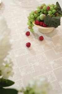 Close-up of white floral embroidery and ruffled edge on a cotton tablecloth in French style