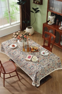 Detail of vintage floral jacquard tablecloth with elegant white tassel fringe edges