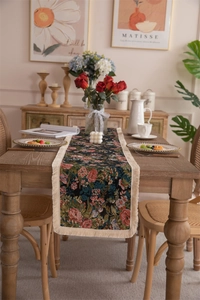 Detailed texture of vintage floral jacquard table runner with beige fringe tassels