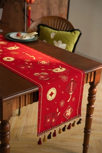 Detail of red New Year table runner with gold embroidery, lanterns, and colorful tassels