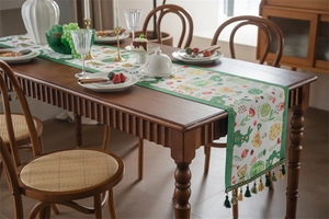 Detail of Easter table runner with bunny floral pattern and decorative tassel fringe