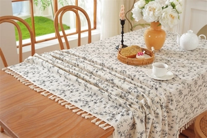 Detailed macro view of retro floral jacquard cotton tablecloth with handmade tassel edges