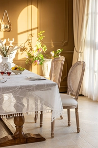 Detail of French lace tablecloth with leaf patterns and elegant white fringe borders