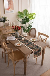Close-up of floral jacquard table runner with vintage rose patterns and tassel fringe