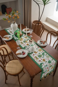 Detailed view of woven Easter table runner featuring rabbits, eggs and green tassels