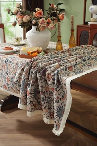 Close-up of vintage floral jacquard tablecloth with elegant white fringe details