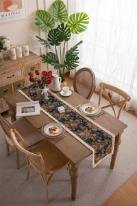 Close-up of vintage floral jacquard table runner with decorative cream tassels