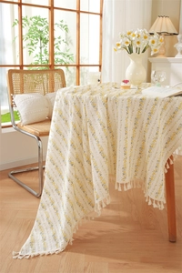 Detail of floral printed cotton tablecloth featuring elegant white fringe tassels on edge