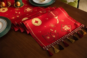 Close-up of red Chinese New Year table runner featuring golden lanterns and silk tassels