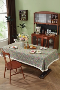 Detail of vintage floral tablecloth with delicate beige fringe edges and retro pattern
