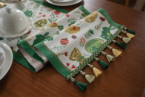 Detail of Easter table runner featuring woven rabbit patterns and colorful tassels