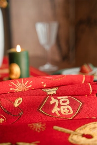 Macro shot of red jacquard fabric with golden Fu character and intricate embroidery