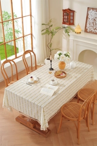 Detailed view of pastoral cotton tablecloth with yellow floral patterns and cream tassels