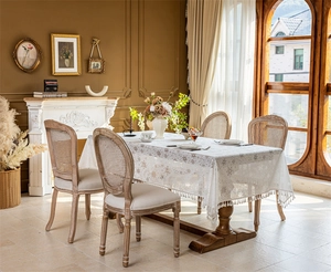 Close-up of white lace tablecloth with snowflake patterns and elegant fringe tassels