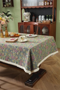 Macro detail of retro floral jacquard table runner with decorative cream cotton tassels