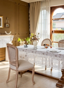 Detail of white lace tablecloth with snowflake patterns and delicate fringe borders