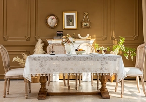 Detail of French lace tablecloth with hollow flower patterns and elegant fringe edges