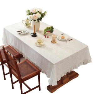White cotton tablecloth with floral embroidery and ruffled edges in French rustic style