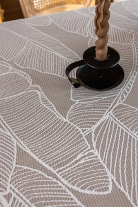Close-up of beige woven tablecloth featuring white leaf vein texture and thick fabric