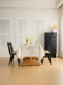 Close-up of yellow floral embroidery and dense tassel fringe on a rectangular tablecloth