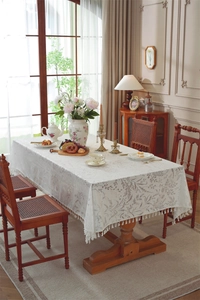Detail of French floral lace tablecloth with leaf jacquard pattern and white tassels