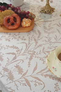 Close-up of French vintage lace tablecloth featuring leaf patterns and rustic breakfast set