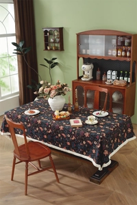 Macro shot of vintage jacquard tablecloth featuring floral patterns and white fringe edge
