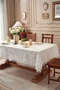 Detail of French lace tablecloth with leaf embroidery and elegant fringe tassels