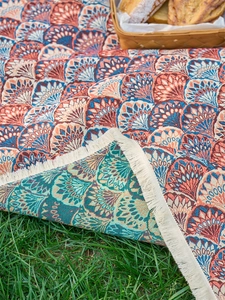 Detail of bohemian jacquard picnic blanket showing vibrant scallop patterns and fringe