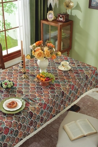 Detailed view of bohemian jacquard tablecloth with ethnic floral patterns and white fringe