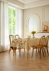 Close-up of floral jacquard embroidery with white tassel fringe on a rectangular tablecloth