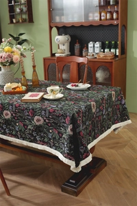 Close-up of floral jacquard tablecloth with elegant cream fringe and dark vintage pattern