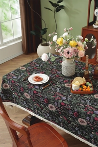 Close-up of vintage floral jacquard tablecloth with elegant cream fringe tassels