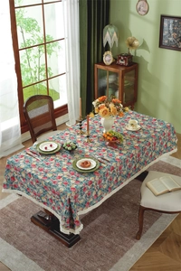 Detail of vintage floral tablecloth with intricate jacquard weave and white fringe edge