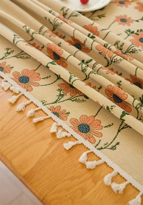 Detailed close-up of pastoral floral jacquard fabric with white cotton fringe tassels
