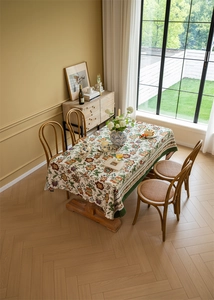 Close-up of vintage floral jacquard tablecloth with bohemian pattern on wooden dining table