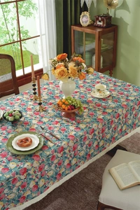 Detail of floral jacquard tablecloth featuring vintage patterns and white fringe edges