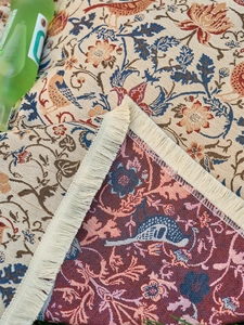 Detailed macro shot of vintage floral jacquard fabric with elegant tassel edge detail