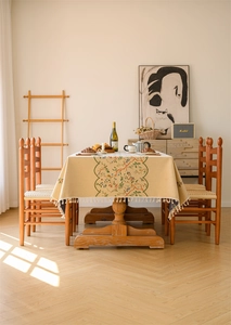Detail of floral jacquard tablecloth featuring elegant fringe and vintage patterns